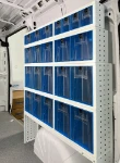 A van racking system with transparent tilting containers on the right