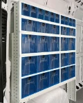A van racking system with transparent tilting containers on the left