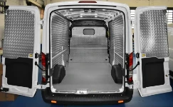 A non-slip plywood floor liner and aluminium bodywork liners in a Transit