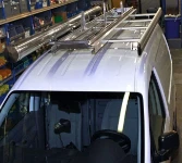 A pivoting ladder rack with a pipe carrier on a Caddy