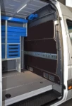 The bulkhead liner in the Sprinter showing the cargo rail and cable holder
